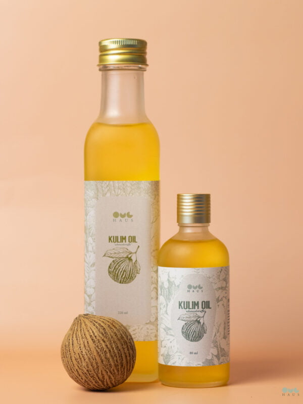 Both variants of the OYLHAUS Kulim Oil product. 220ml and 80ml bottles next to each other with a Kulim Fruit in front.